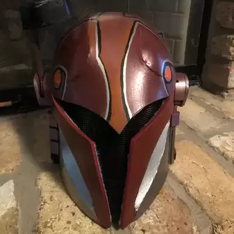 A brown and gold painted Sabine helmet from the front view